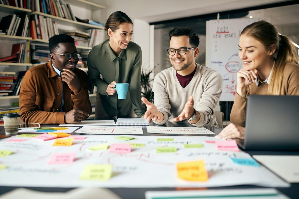 2021 Here We Are! 7 Happy creative marketing team working on new business project in the office.